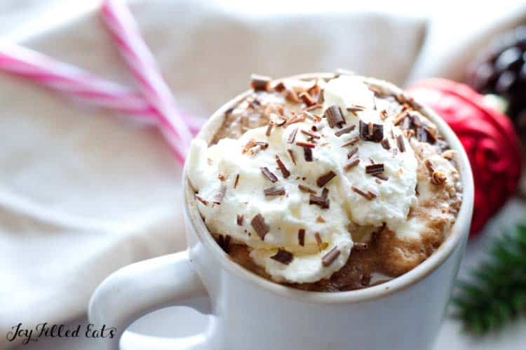 close up on mug of keto peppermint mocha topped with whipped cream and chocolate shavings
