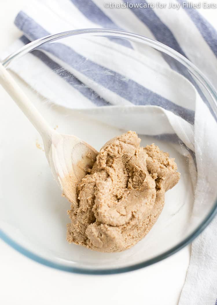 cinnamon roll protein ball dough in mixing bowl with spoon