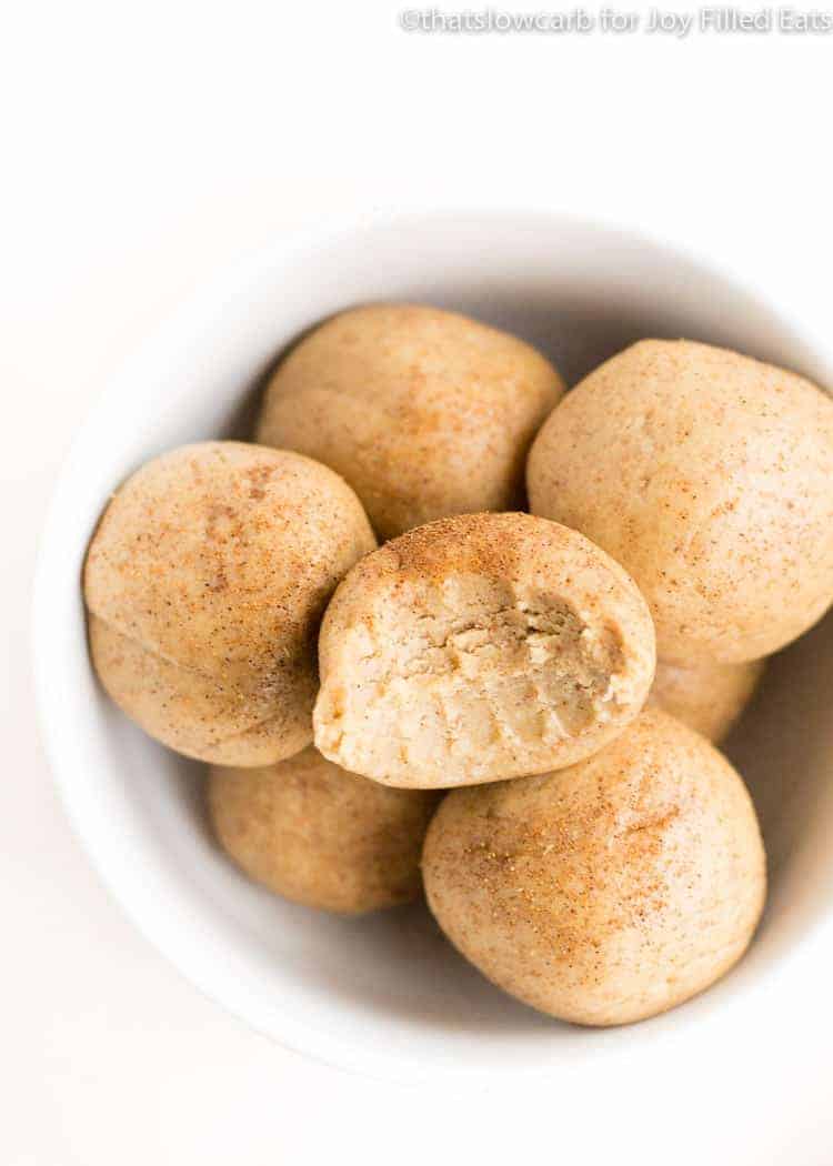 bowl of cinnamon roll protein balls with bite missing from top ball