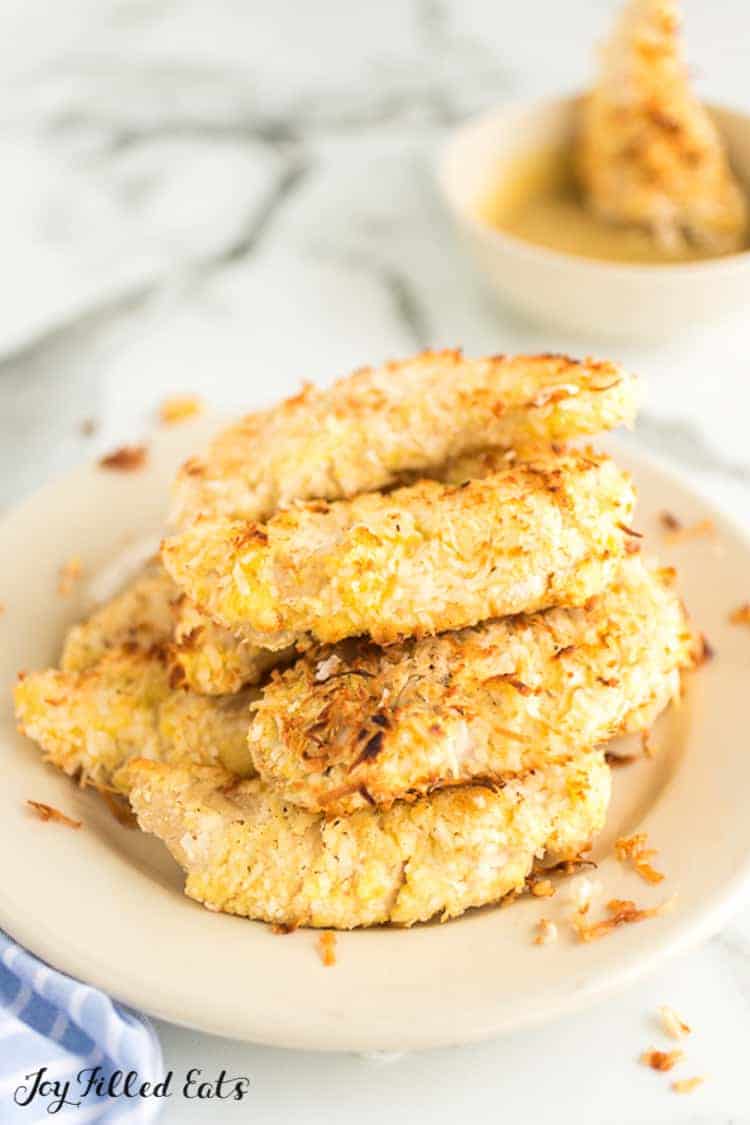 a white plate with a pile of coconut chicken tenders