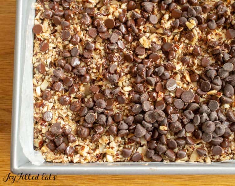 baking dish filled with no bake keto granola bars topped with chocolate chips