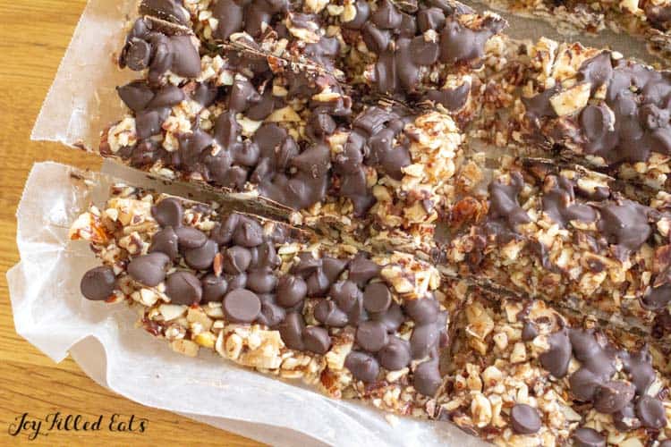 no bake keto granola bars being cut on parchment paper