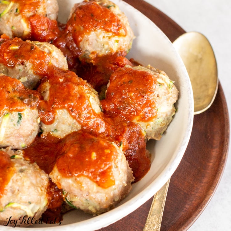 close up of the keto turkey meatballs in a bowl covered in marinara sauce place with a spoon