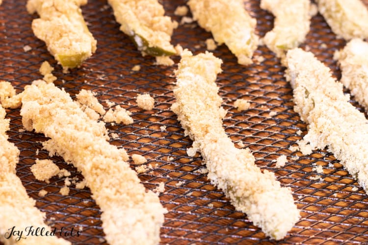 breaded pickles on a air fryer rack to be fried