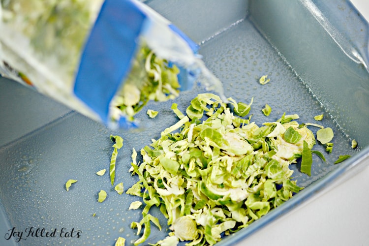 shaved Brussels sprouts being poured into casserole dish