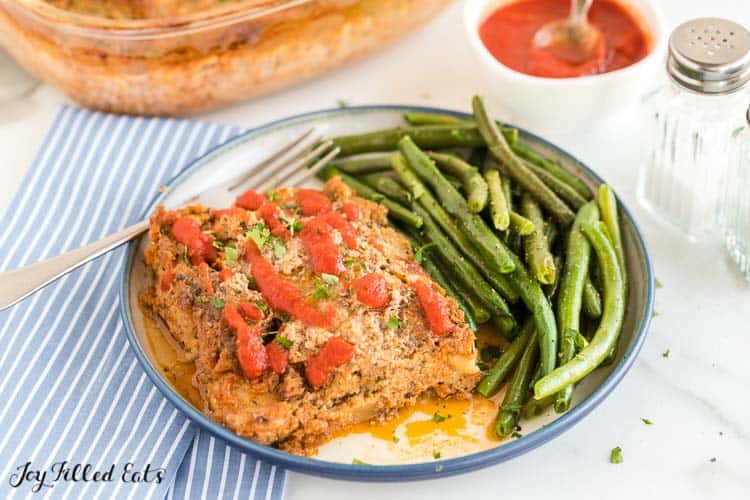 serving of keto turkey meatloaf with a side of green beans on a plate with fork
