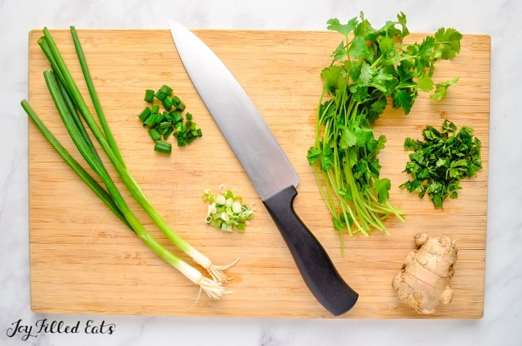 cutting board and chef knife with vegetable ingredients for chicken pad thai