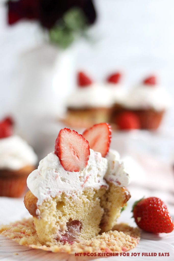 A view of a strawberry cupcake sliced in half.