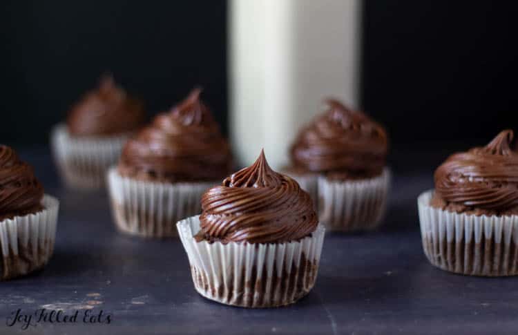 chocolate cupcakes with chocolate cream cheese icing arranged on table