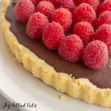 chocolate tart topped with raspberries close up