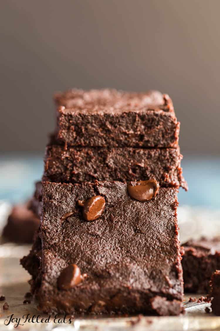 stack of flourless fudge brownies with one brownie leaning on stack close up
