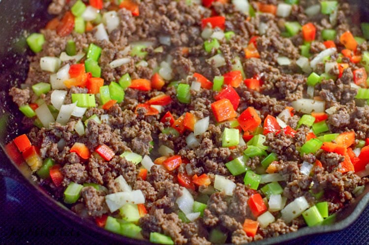 ground meat and diced vegetables in skillet close up