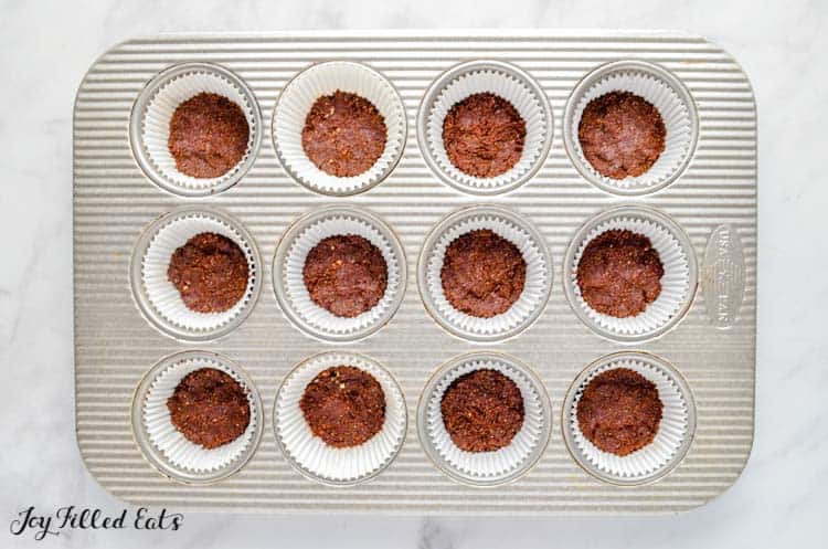 muffin tin filled with no-bake cheesecake Oreo crust