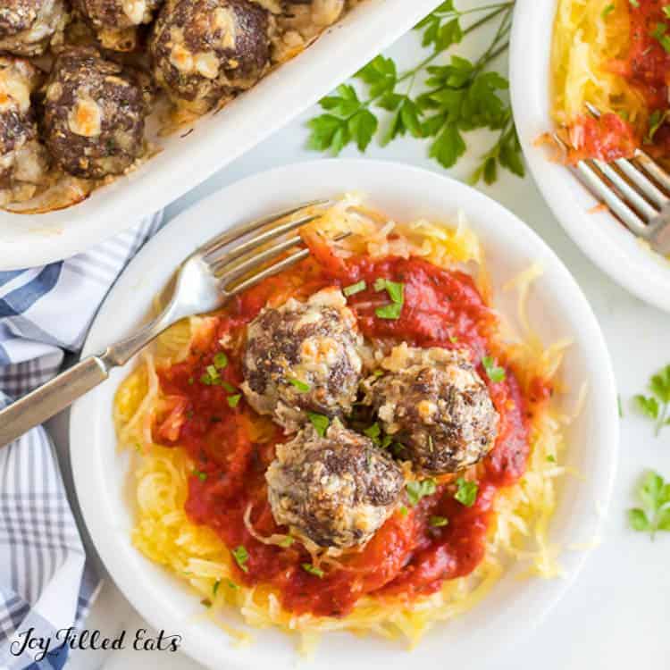 meatballs on top of a plate of spaghetti squash and sauce with fork from above