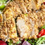 pecan crusted chicken sliced on a green salad close up
