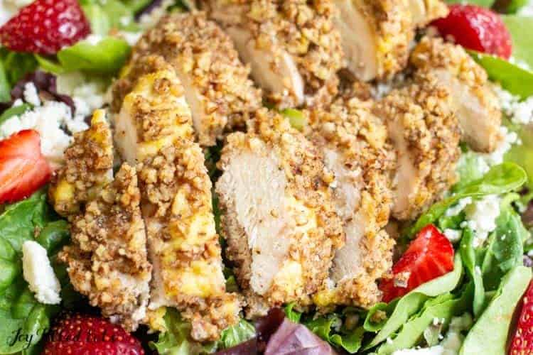 pecan crusted chicken sliced on a green salad close up