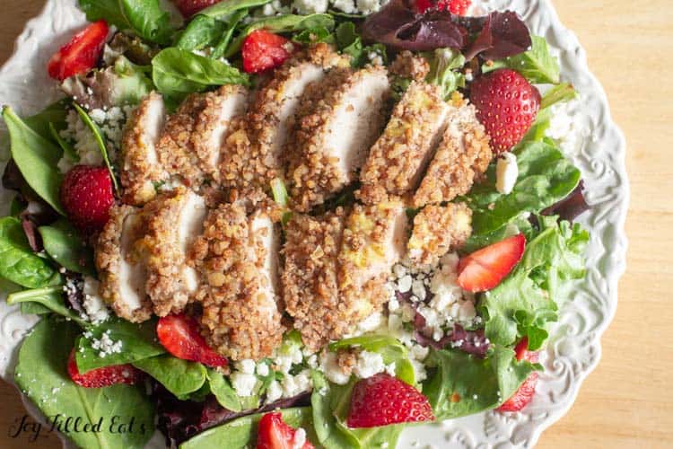 pecan crusted chicken sliced on a green salad