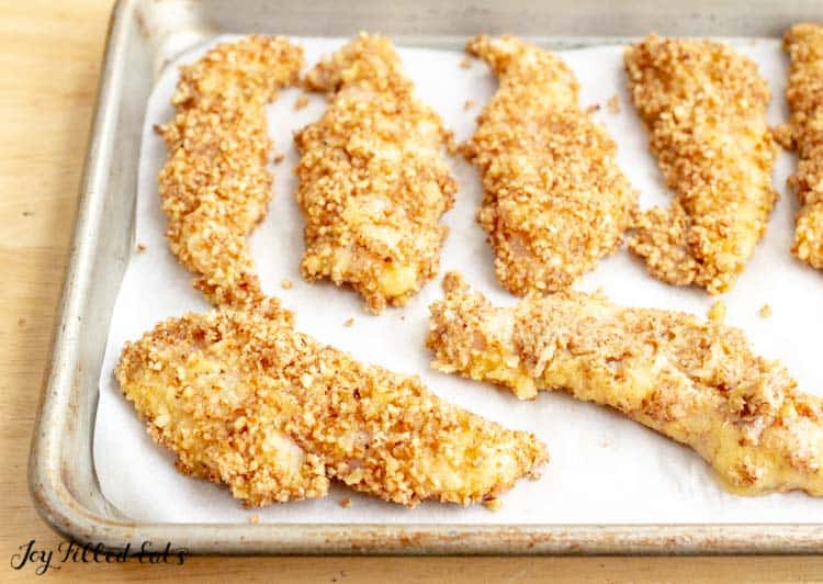 pecan crusted chicken on a parchment lined sheet pan