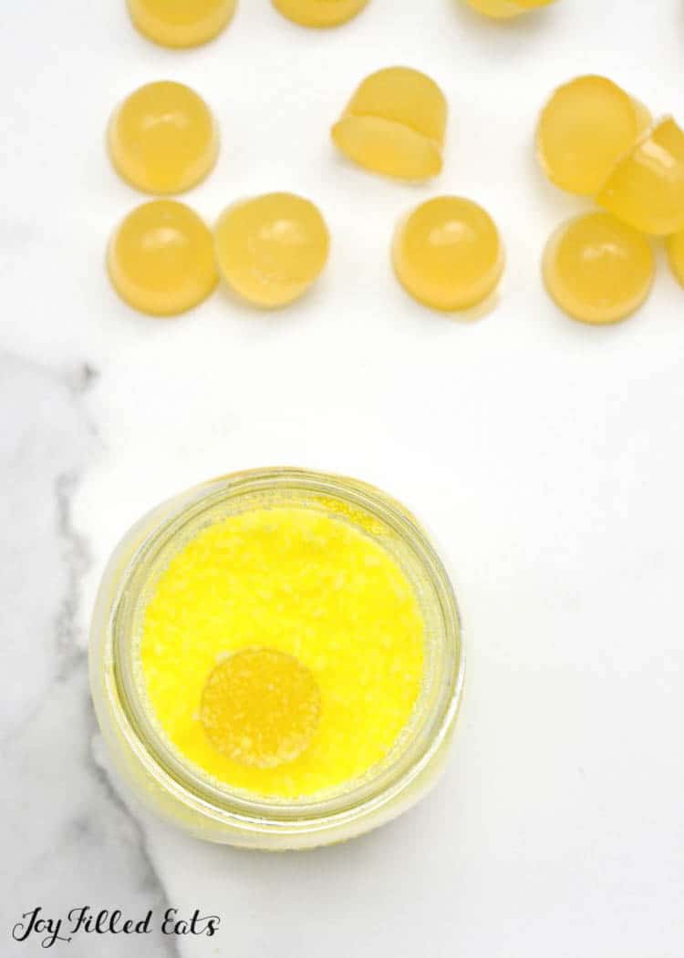 lemon gumdrops next to a mason jar of sugar coating