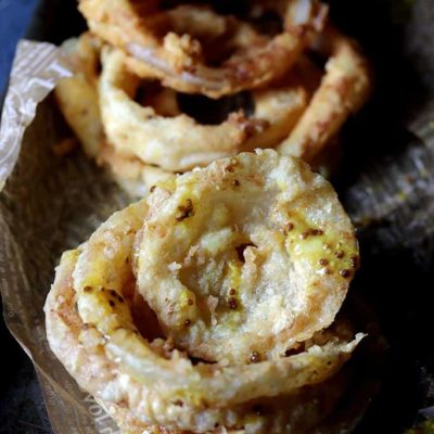 keto onion rings stacked on top of one another.