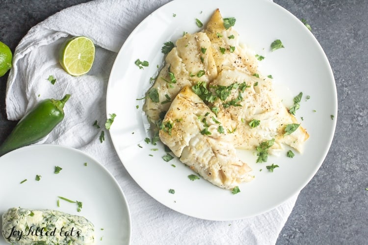 plate of pan-seared cod set nest to a bowl of cilantro-lime butter