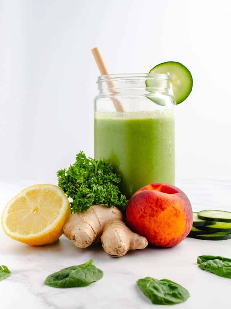 low carb green smoothie in a jar with ingredients around it
