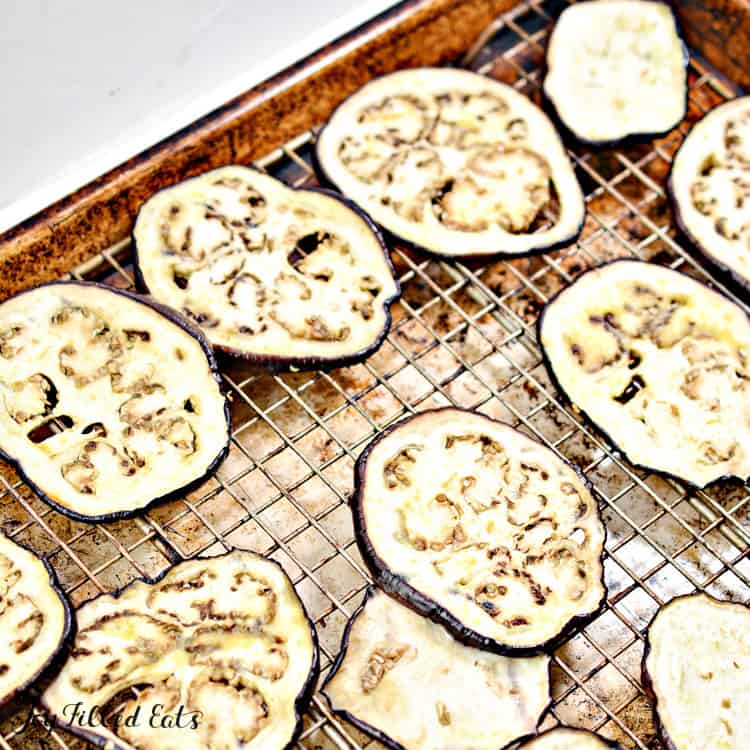 eggplant slices on a drying rack in a sheet pan close up