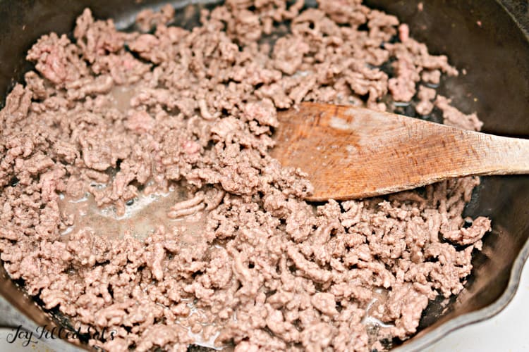 ground meat in skillet with wooden spoon