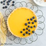 Lemon Curd Tart decorated with blueberries on a wire cake stand from above