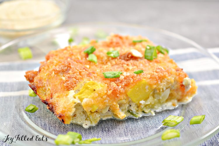slice of yellow squash casserole on plate topped with chopped green onions