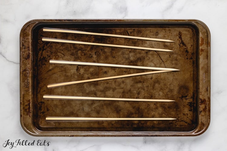 bare skewers placed on a sheet pan