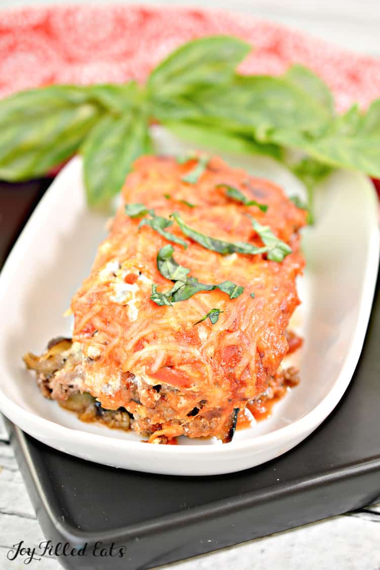 close up on serving of eggplant lasagna garnished with basil leaves
