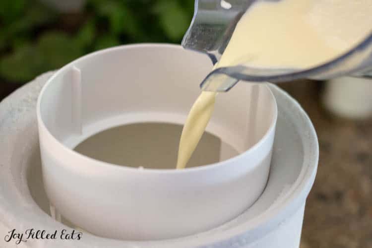 custard mixture being poured into ice cream making close up