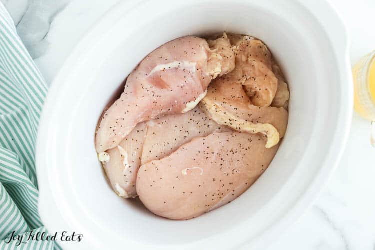 seasoned raw chicken breasts in crockpot from above