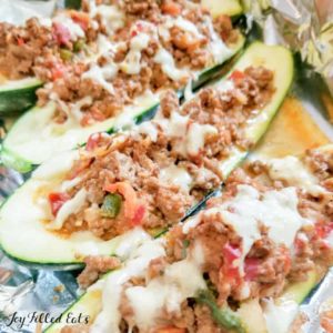 Taco Zucchini Boats lined in a row topped with melted cheese