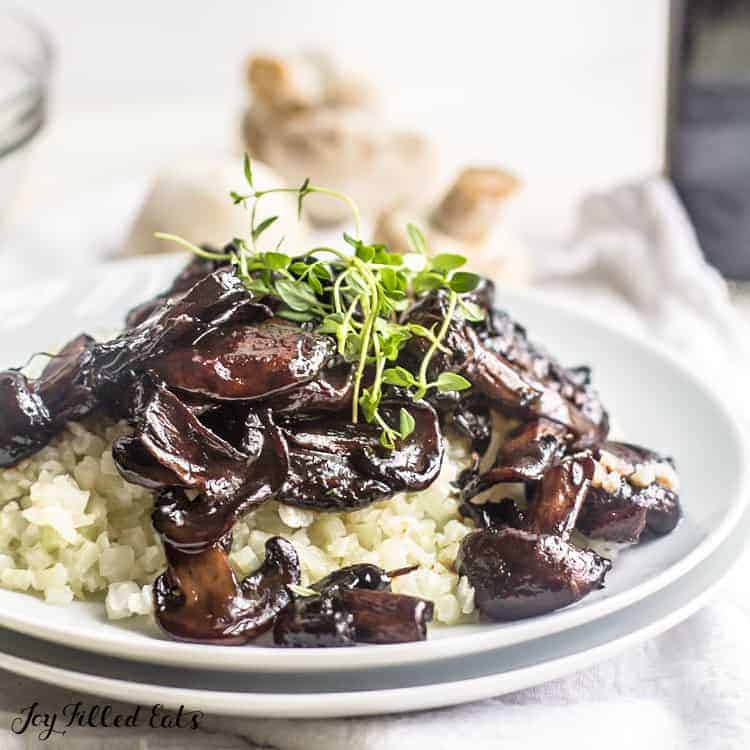 Plate of balsamic mushrooms served over riced cauliflower topped with micro greens