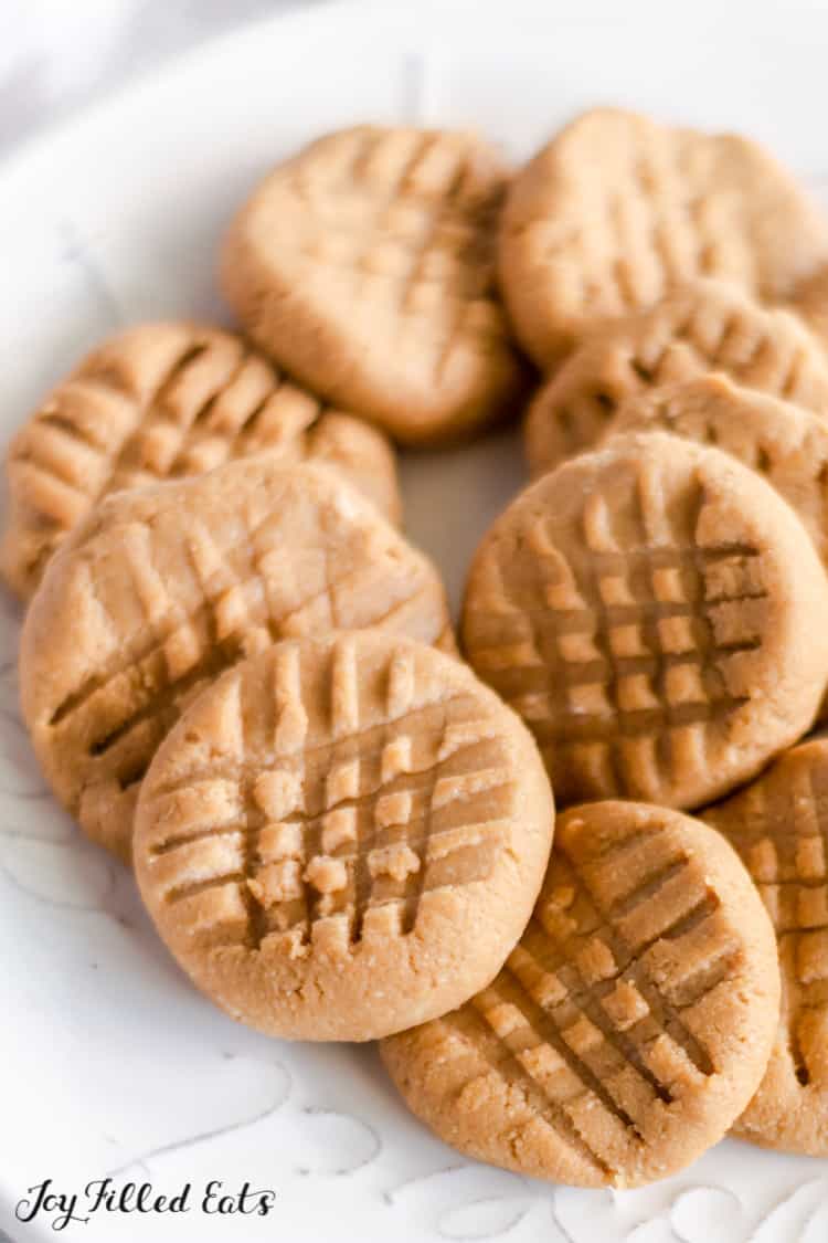 close up of keto no bake peanut butter cookies piled onto white plate