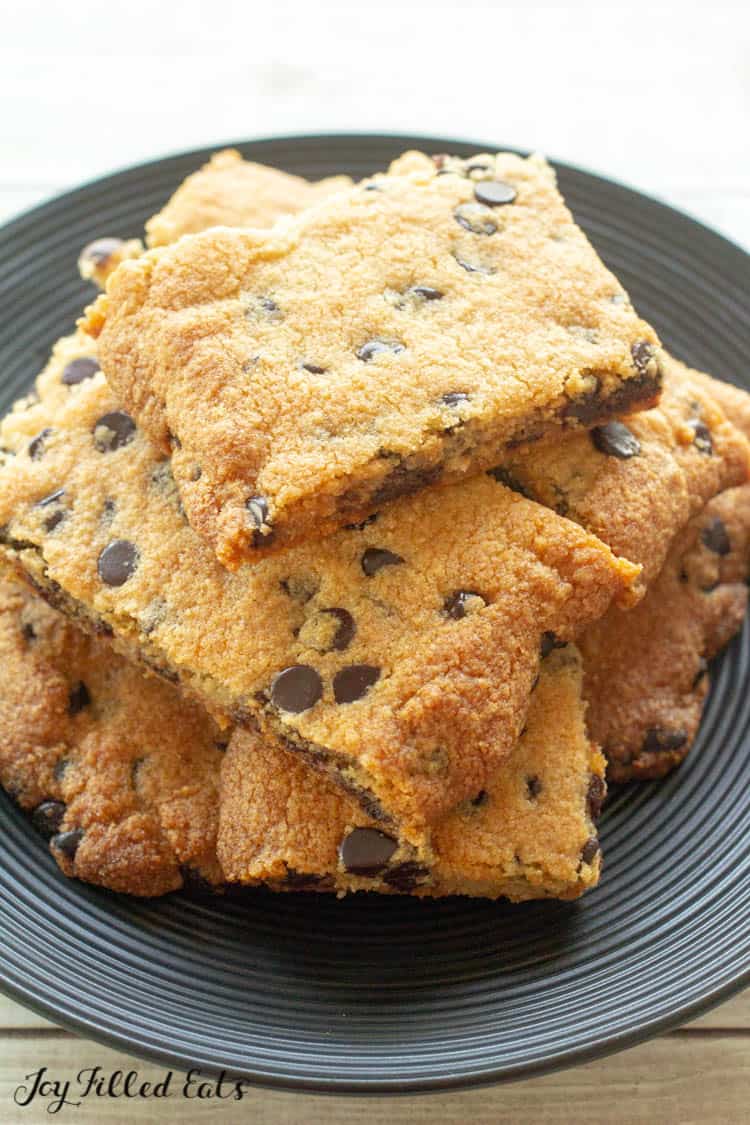 overhead view of pile of chocolate chip cookie bars on black plate