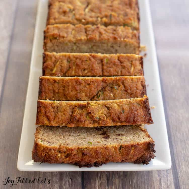 keto zucchini loaf cut into slices on a white, rectangular plate