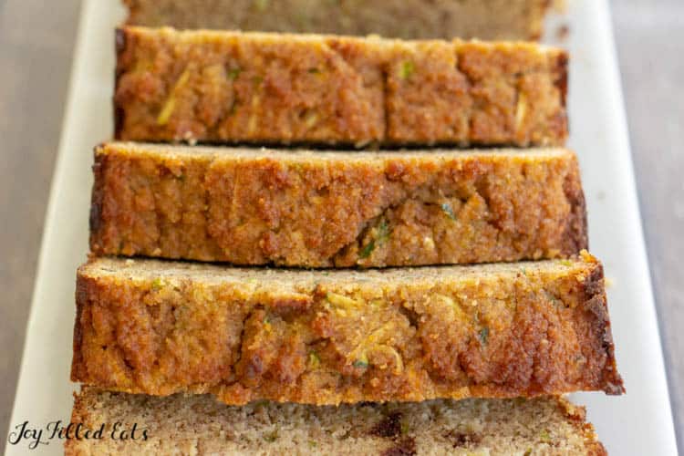 close up of keto zucchini bread sliced on a white, rectangular plate