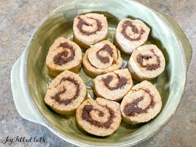 overhead view of pumpkin spice cinnamon rolls placed in pie plate before baking