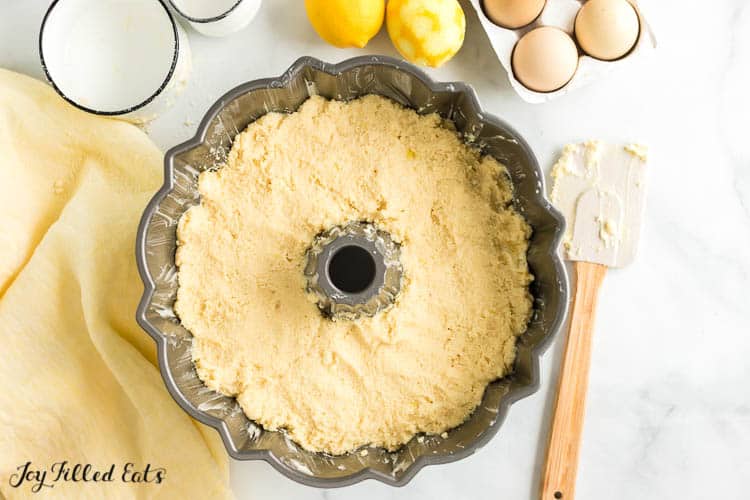 overhead view of bundt pan surrounded by spatula, lemons and eggs
