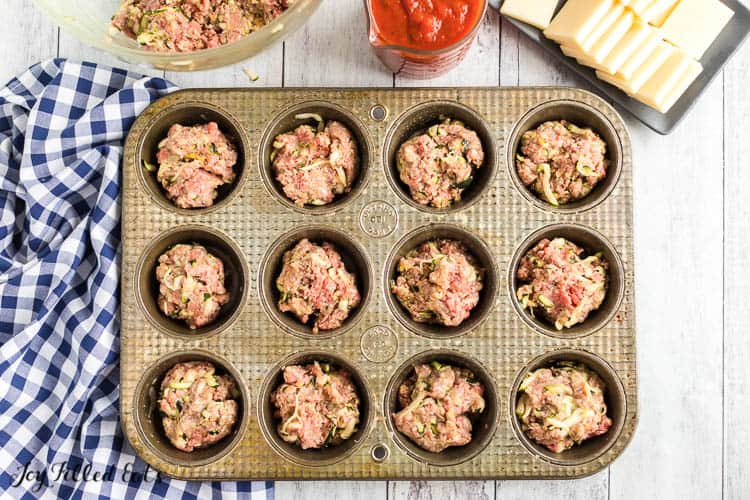 overhead view of mini meatloaves mixture in muffin tin before baking