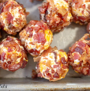 Close up shot of Bacon Cheddar Mini Cheese Balls on a metal tray.
