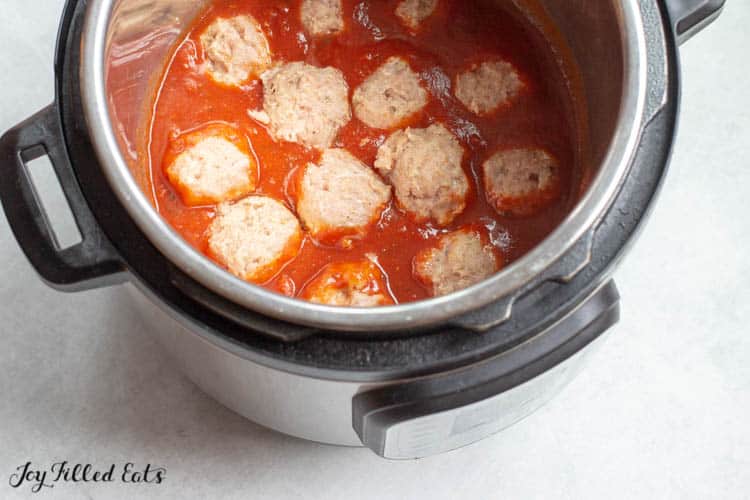overhead view of shaped meatballs and sauce in instant pot