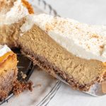 a slice of keto pumpkin cheesecake lifted up on a pie server