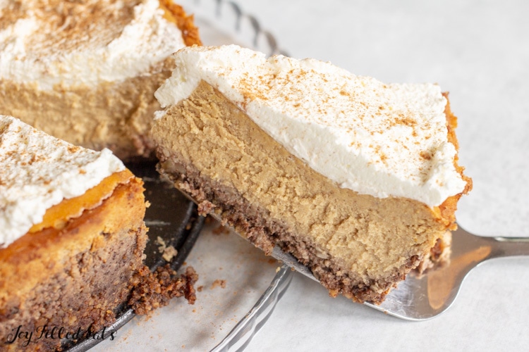 a slice of keto pumpkin cheesecake lifted up on a pie server