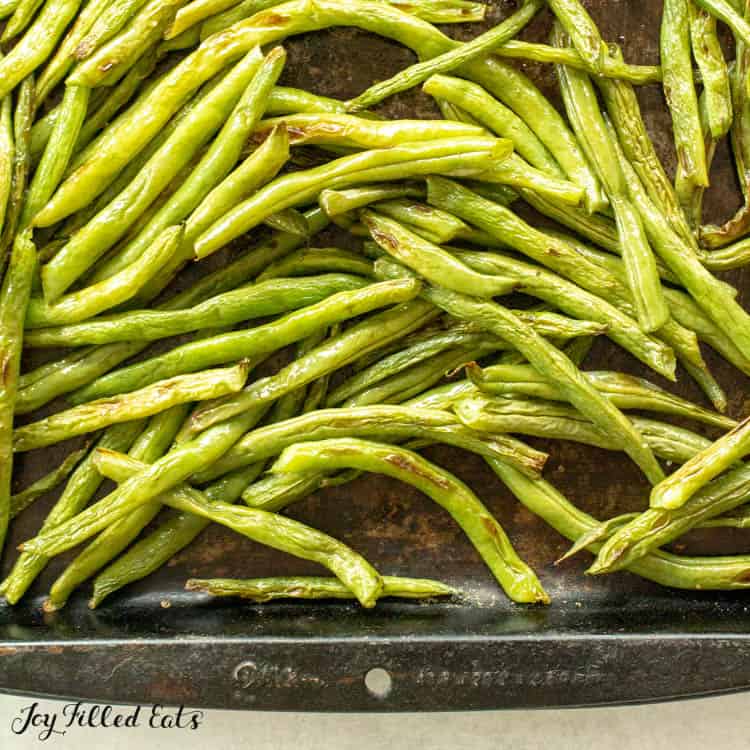 close up of roasted green beans on sheet pan