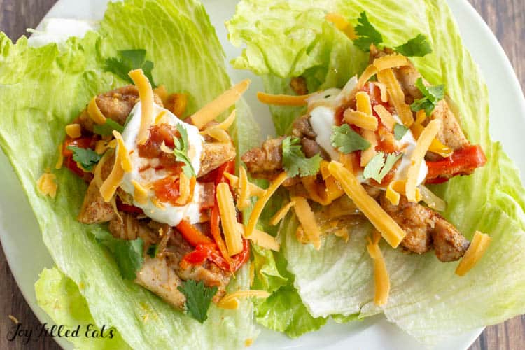 Lettuce leafs with keto Chicken Fajitas filling, topped with sour cream and shredded cheese