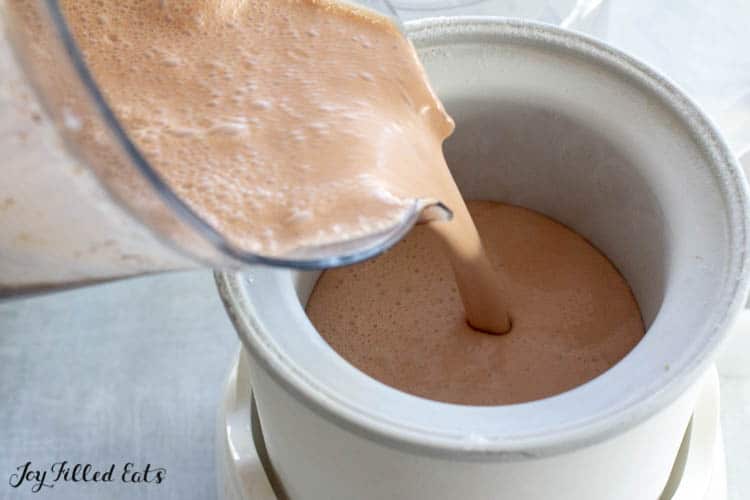 blender pitcher pouring ice cream mixture into ice cream maker